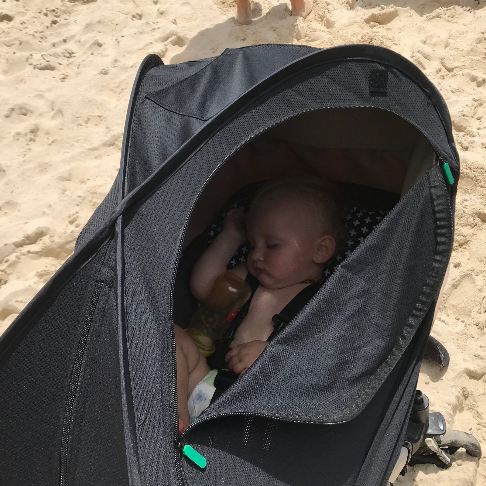 Baby in a stroller on a sandy beach